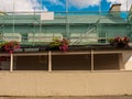 Construction site with scaffolding in town decorated with flowers in a tourist area. Small wooden safety passage for people. Blue Royalty Free Stock Photo