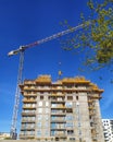 Construction site with scaffoldings and a crane arm