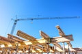 House building: Shell of a new house with ceiling supports and a huge crane at a site and blue sky Royalty Free Stock Photo