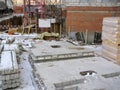 A construction site is shown with concrete slabs, building materials, and winter weather. Royalty Free Stock Photo