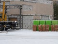 Construction site with small crane and pallets with red bricks