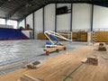 Construction site of sports hall, basketball court renovation, school gym indoor changing hardwood parquet flor and Royalty Free Stock Photo