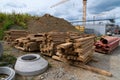 Construction site stacked with wooden beams and pipes