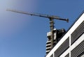 Construction site in sunlight. Skyscraper tower with crane, modern facade, exterior structure, Royalty Free Stock Photo