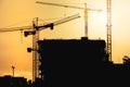 construction site at sunset with silhouettes of tower cranes Royalty Free Stock Photo