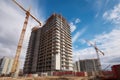 construction site with towering crane, working on high-rise building