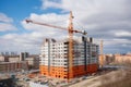 construction site with towering crane, working on high-rise building