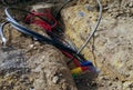 A construction site trench containing multiple cables, including black, red, green, yellow, and blue Royalty Free Stock Photo