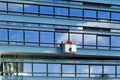 Construction site. Wokers clean the glass wall of new office building. Vilnius, Lithuania - June 29, 2016.