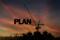 A construction site with the word PLAN written on a crane. The crane is a large, powerful machine that is used to lift heavy