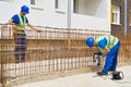 Construction site worker drills with a drill while his colleague checks the work done stock picture Royalty Free Stock Photo