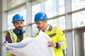 Construction site worker and engineer discussing on blueprint project Royalty Free Stock Photo