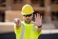 Construction site worker in helmet working outdoor. A builder in a safety hard hat at constructing buildings. American Royalty Free Stock Photo