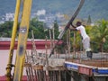 Construction site worker manipulating cement hose from pump