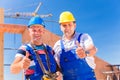 Construction site workers building walls on house