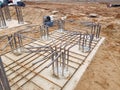 Construction site preparation for industrial building with rebar framework and pile field on sandy terrain Royalty Free Stock Photo