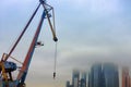 Construction of skyscrapers and high-rise buildings against a cloudy sky. The boom of a tower crane in the fog in Moscow-city Royalty Free Stock Photo