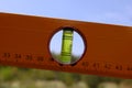 Construction spirit level tool on natural summer background. Bubble level instrument for calibration, levelling, and Royalty Free Stock Photo