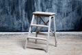 Construction stool near the dark wall, smeared with chalk Royalty Free Stock Photo