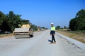 Construction supervisor walking along a new road project during sunrise, symbolizing infrastructure development and future Royalty Free Stock Photo
