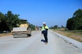 Construction supervisor walking along a new road project during sunrise, symbolizing infrastructure development and future Royalty Free Stock Photo