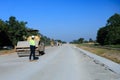Construction supervisor walking along a new road project during sunrise, symbolizing infrastructure development and future Royalty Free Stock Photo