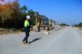 Construction supervisor walking along a new road project during sunrise, symbolizing infrastructure development and future Royalty Free Stock Photo