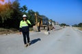 Construction supervisor walking along a new road project during sunrise, symbolizing infrastructure development and future Royalty Free Stock Photo