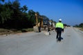 Construction supervisor walking along a new road project during sunrise, symbolizing infrastructure development and future Royalty Free Stock Photo