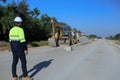 Construction supervisor walking along a new road project during sunrise, symbolizing infrastructure development and future Royalty Free Stock Photo