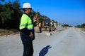 Construction supervisor walking along a new road project during sunrise, symbolizing infrastructure development and future Royalty Free Stock Photo