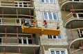 Construction suspended cradle with workers on a newly built high-rise building