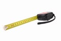 Construction tape measure in black, lying on its side with an open tape. Isolated on a white background. Close up Royalty Free Stock Photo