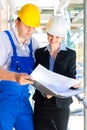 Construction Team with building plans on site Royalty Free Stock Photo