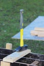 Construction tool hammer with a yellow handle lies on the formwork.