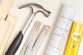Construction tools, architectural blueprint and wooden strips on white plaster background