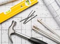 Construction tools with hammer, nails, folding rule and level on architectural blueprint plan flat lay Royalty Free Stock Photo