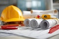 Construction tools and materials including rolled blueprints, measuring tape, red ruler, and yellow hard hat arranged on a Royalty Free Stock Photo