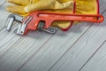 Construction tools red plumbers monkey wrench and yellow work gloves on white vintage wood Royalty Free Stock Photo
