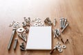 Construction tools. The screws, nuts and bolts arranged around blank spiral bound note book paper on wooden background