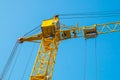 Construction tower crane against the background of the blue sky skyline close