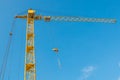 Construction tower crane against the background of the blue sky skyline