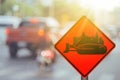 Construction tractor warning sign on blur traffic road with colorful bokeh light abstract background Royalty Free Stock Photo