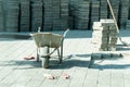 Construction trolley with workers gloves and pavement stone in the background on the street paving site. Royalty Free Stock Photo