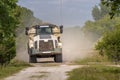 Construction Vehicle - Dump Truck races down dirt road in a forested area