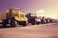 Construction vehicles parked in line at an industrial site. Large trucks in an open pit mine Royalty Free Stock Photo
