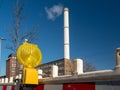 Construction warning lantern on the background of a smoking chimney. Royalty Free Stock Photo