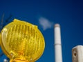 Construction warning lantern on the background of a smoking chimney. Royalty Free Stock Photo