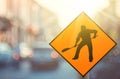 Construction warning sign on blur traffic road with colorful bokeh light abstract background Royalty Free Stock Photo