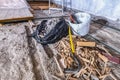 Construction waste debris in black plastic bag and wood chips on old concrete floor, partly cut down old wooden floor in Royalty Free Stock Photo